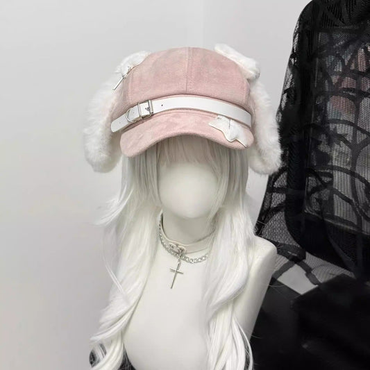 Pink newsboy cap with long white plush dog ears and a white leather belt buckle strap on a mannequin with grey hair.