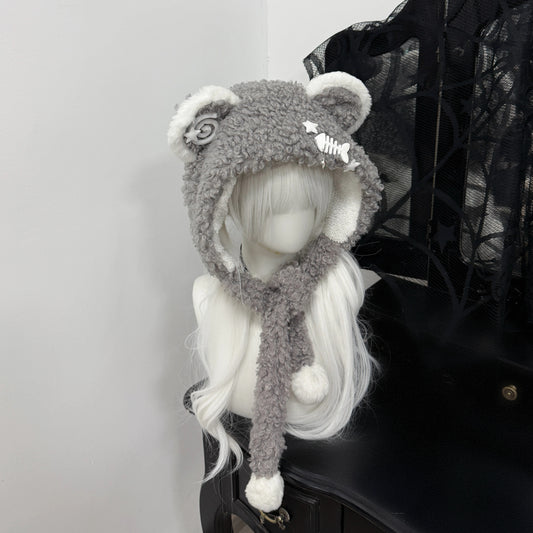 Gray fuzzy bear ear balaclava hat on a white mannequin, featuring white pom-pom ties, a metal fishbone charm, and a spiral patch, Jirai Kei fashion style.