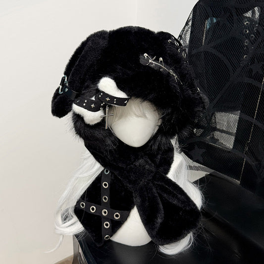 Hardcore black plush bunny ear hood on a mannequin, decorated with silver safety pins, metal eyelets, and a dangling silver cross charm.