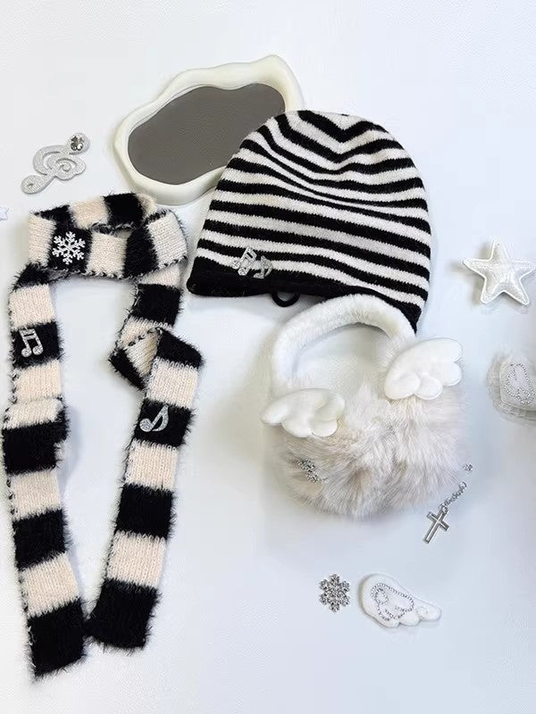 Complete 3-piece winter set featuring a black and white striped beanie, plush snowflake earmuffs, and matching long scarf with musical note charms.