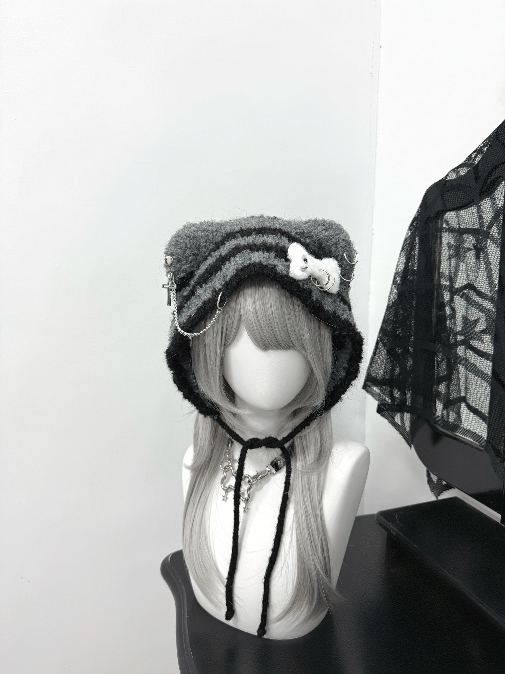 Distressed grey cat ear knit beanie with long buckle earflaps and contrast stitching.