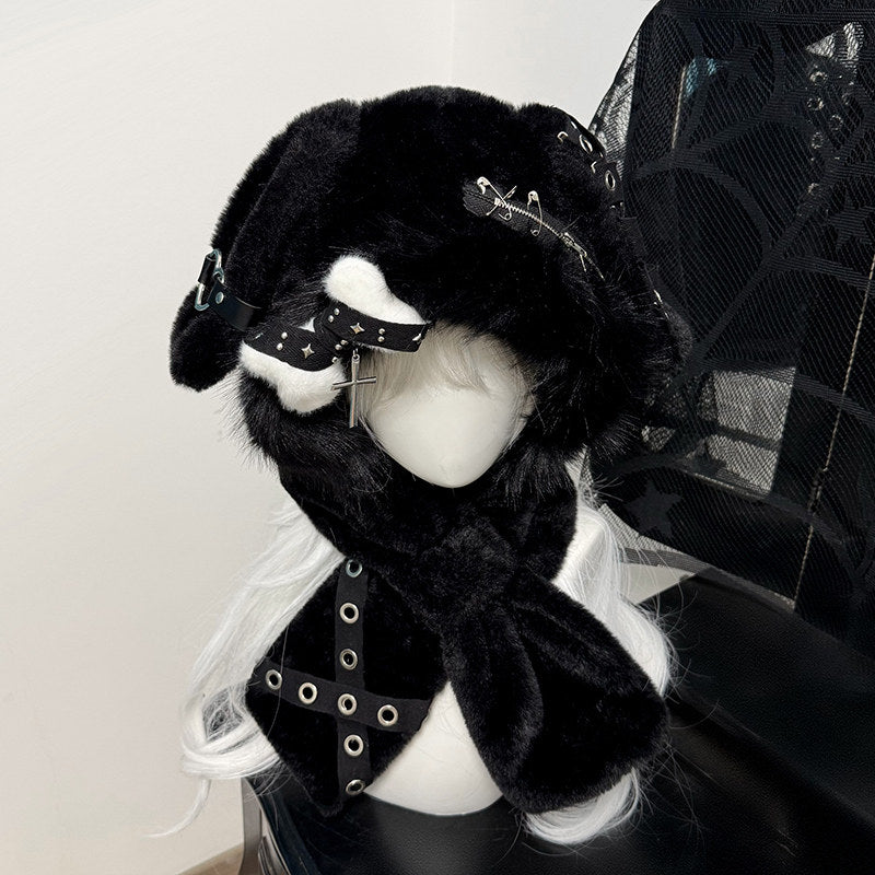 Hardcore black plush bunny ear hood on a mannequin, decorated with silver safety pins, metal eyelets, and a dangling silver cross charm.
