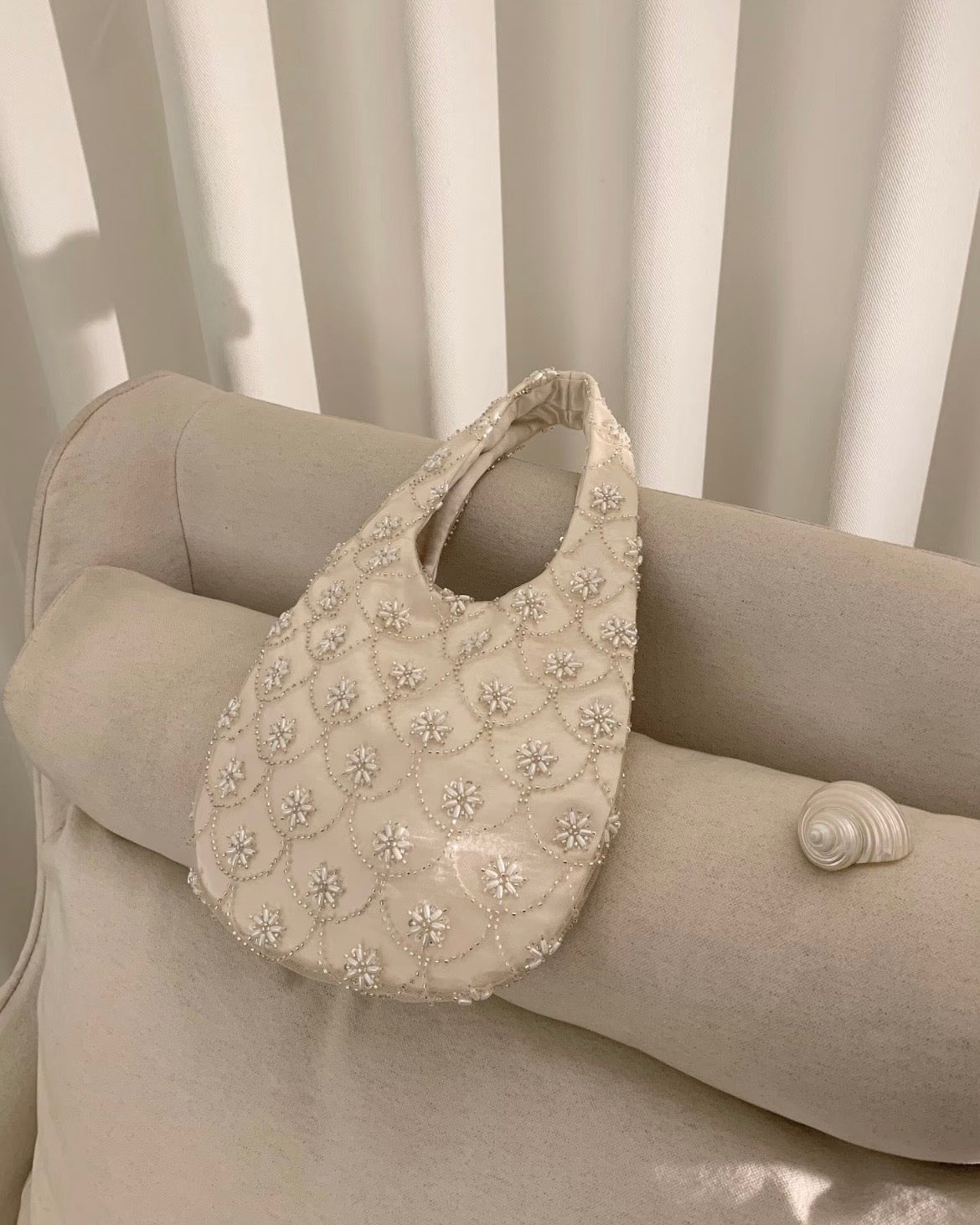 Handmade cream seed bead embroidery eggshell handbag for weddings and evening galas, luxury bridal purse with multi-layer satin lining and intricate floral beadwork.