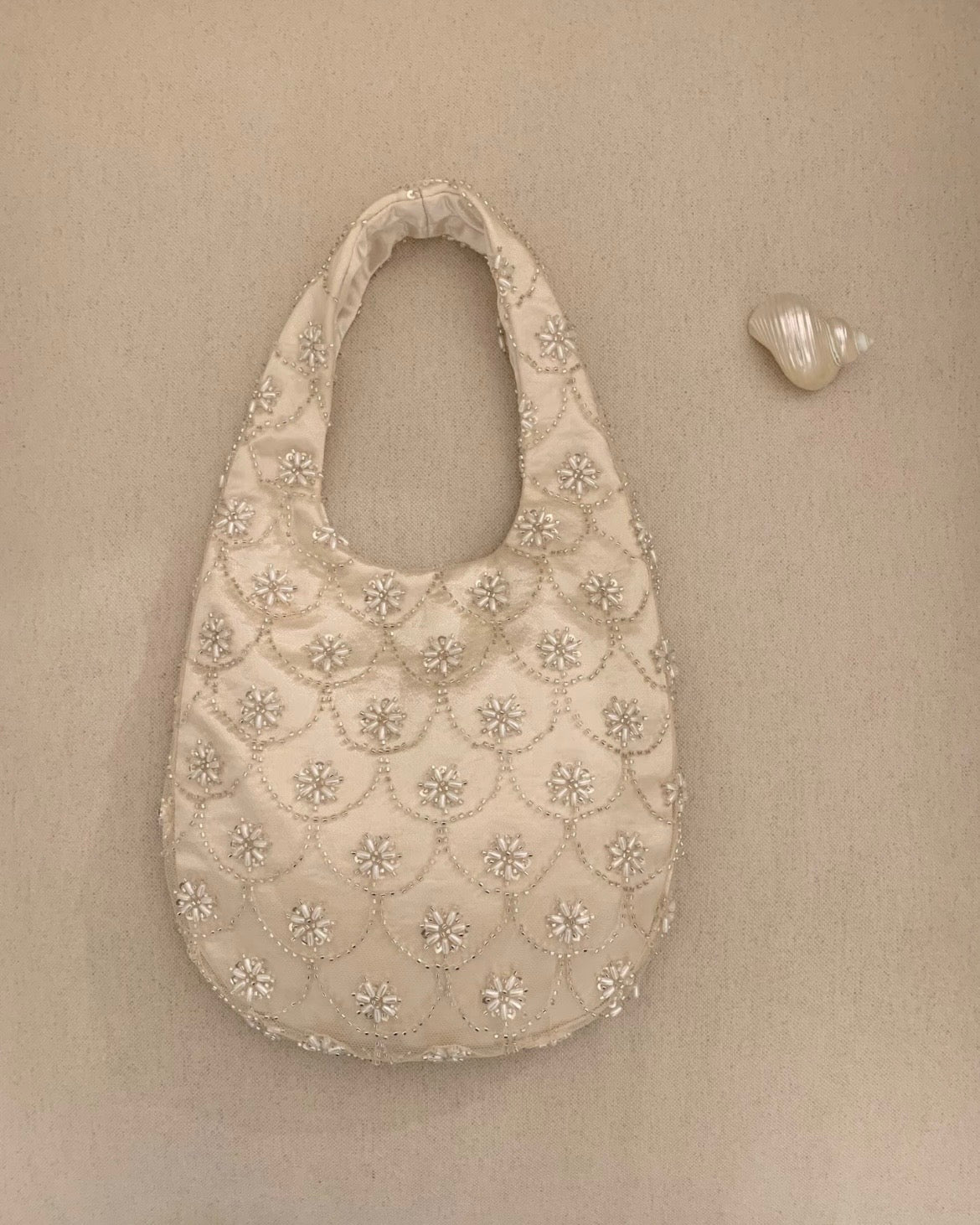 Handmade cream seed bead embroidery eggshell handbag for weddings and evening galas, luxury bridal purse with multi-layer satin lining and intricate floral beadwork.