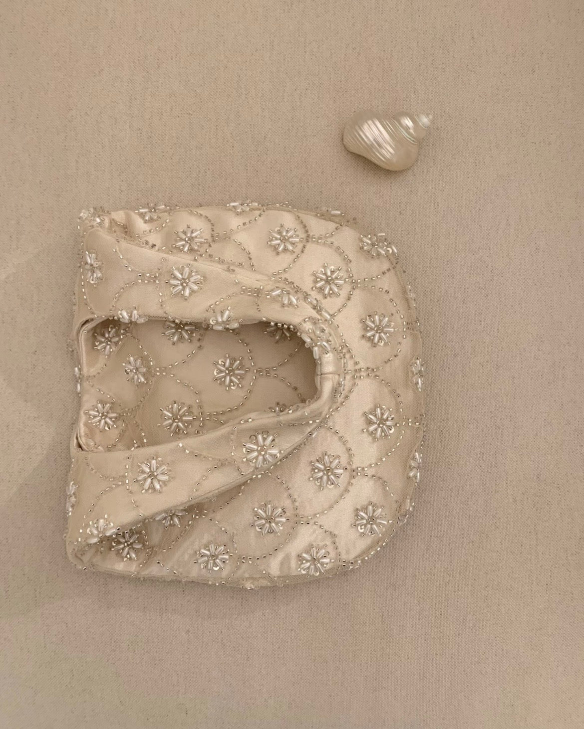 Handmade cream seed bead embroidery eggshell handbag for weddings and evening galas, luxury bridal purse with multi-layer satin lining and intricate floral beadwork.