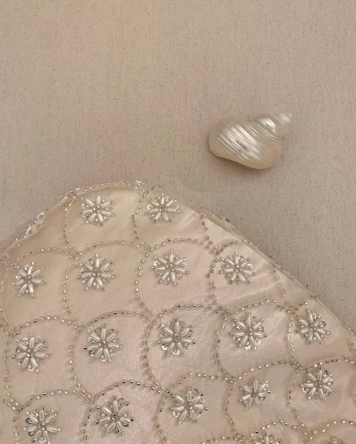 Handmade cream seed bead embroidery eggshell handbag for weddings and evening galas, luxury bridal purse with multi-layer satin lining and intricate floral beadwork.