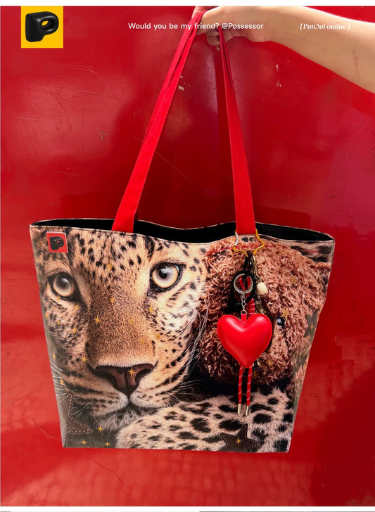 Leopard print bag with red heart and strap on a red background
